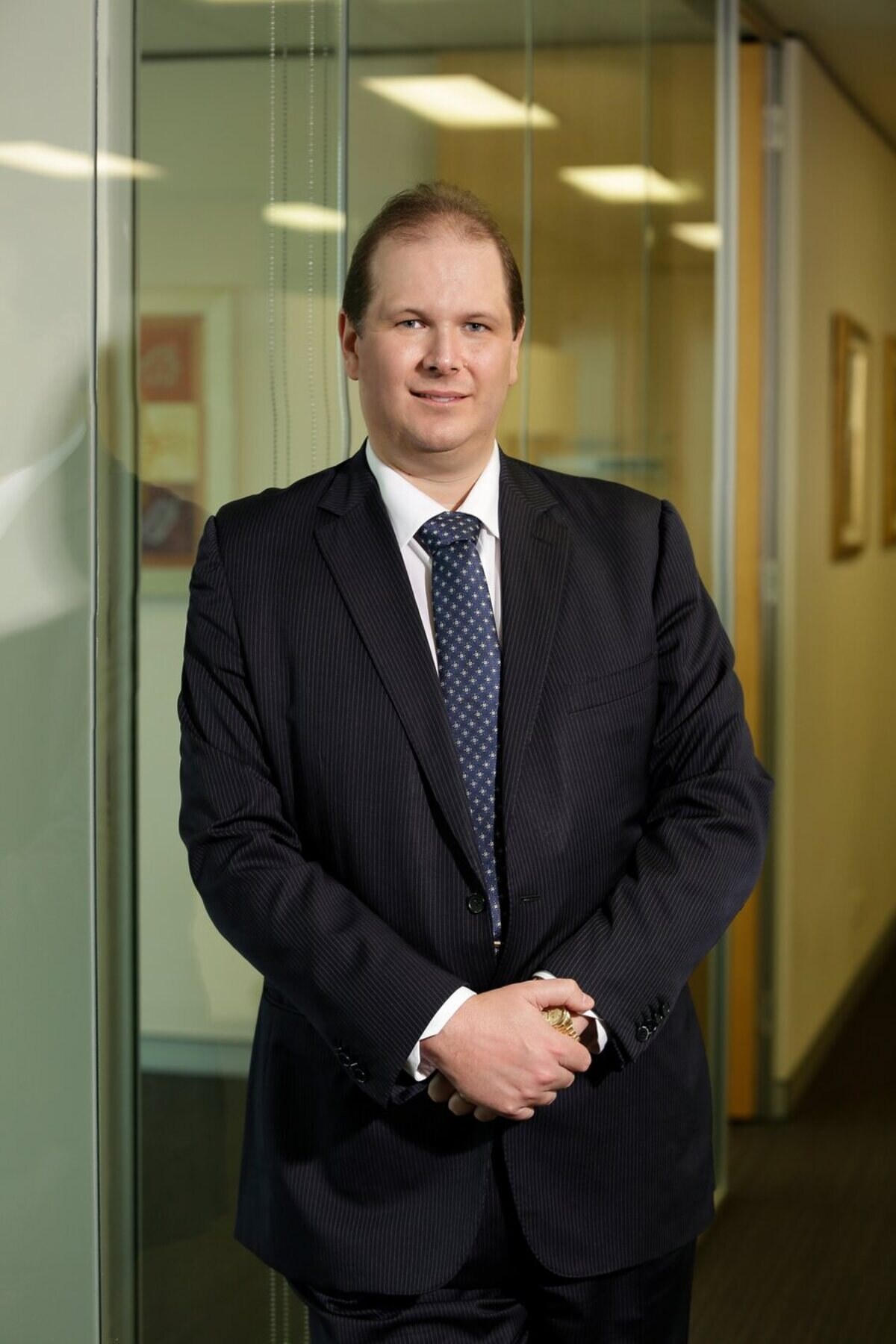 Portrait of Nathan Buzza, founder and principal of Allure Capital, in a dark suit.