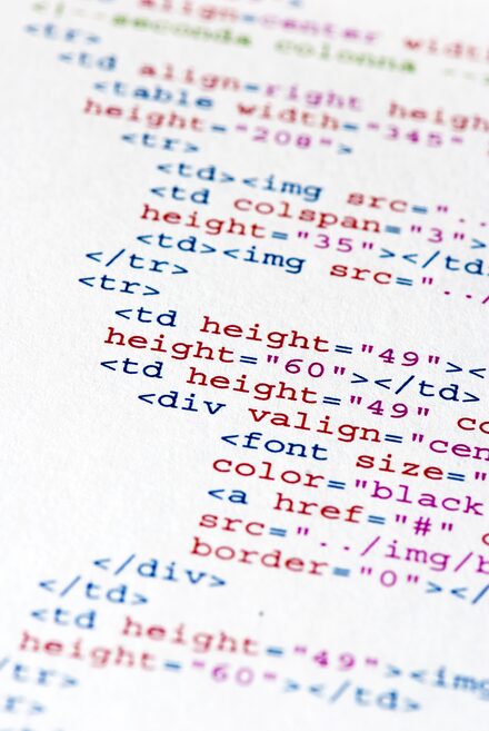 Close-up of coloured HTML markup on paper, suggesting healthcare-software focus.