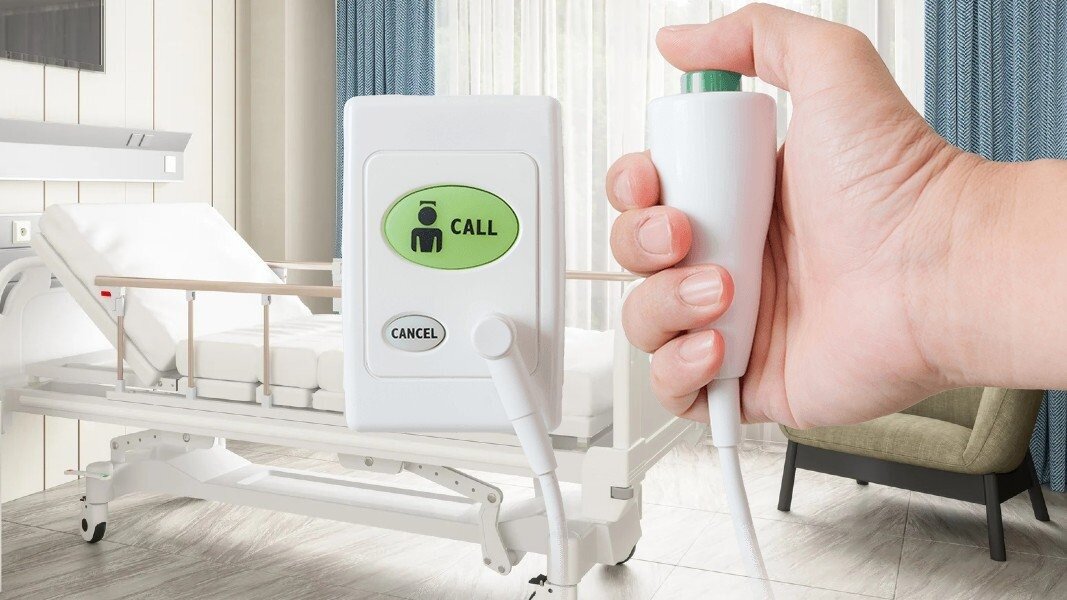 An Austco nurse-call device installed at a hospital bedside.