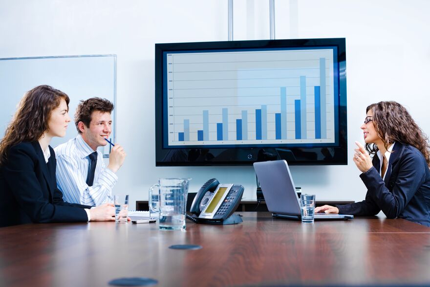 A small team reviewing a quarterly performance chart in a boardroom.