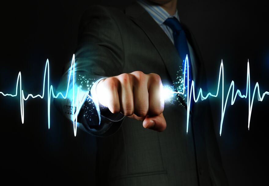 A businessman's fist punching through an ECG waveform — clinical pulse motif.
