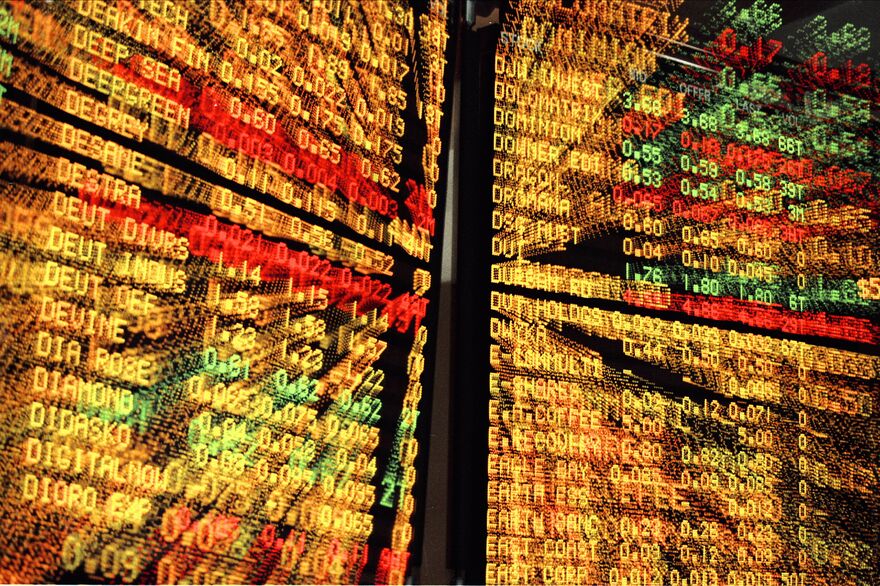 A real ASX-style trading-floor ticker board showing live stock codes and prices — the public-markets backdrop the passive allocation runs against.
